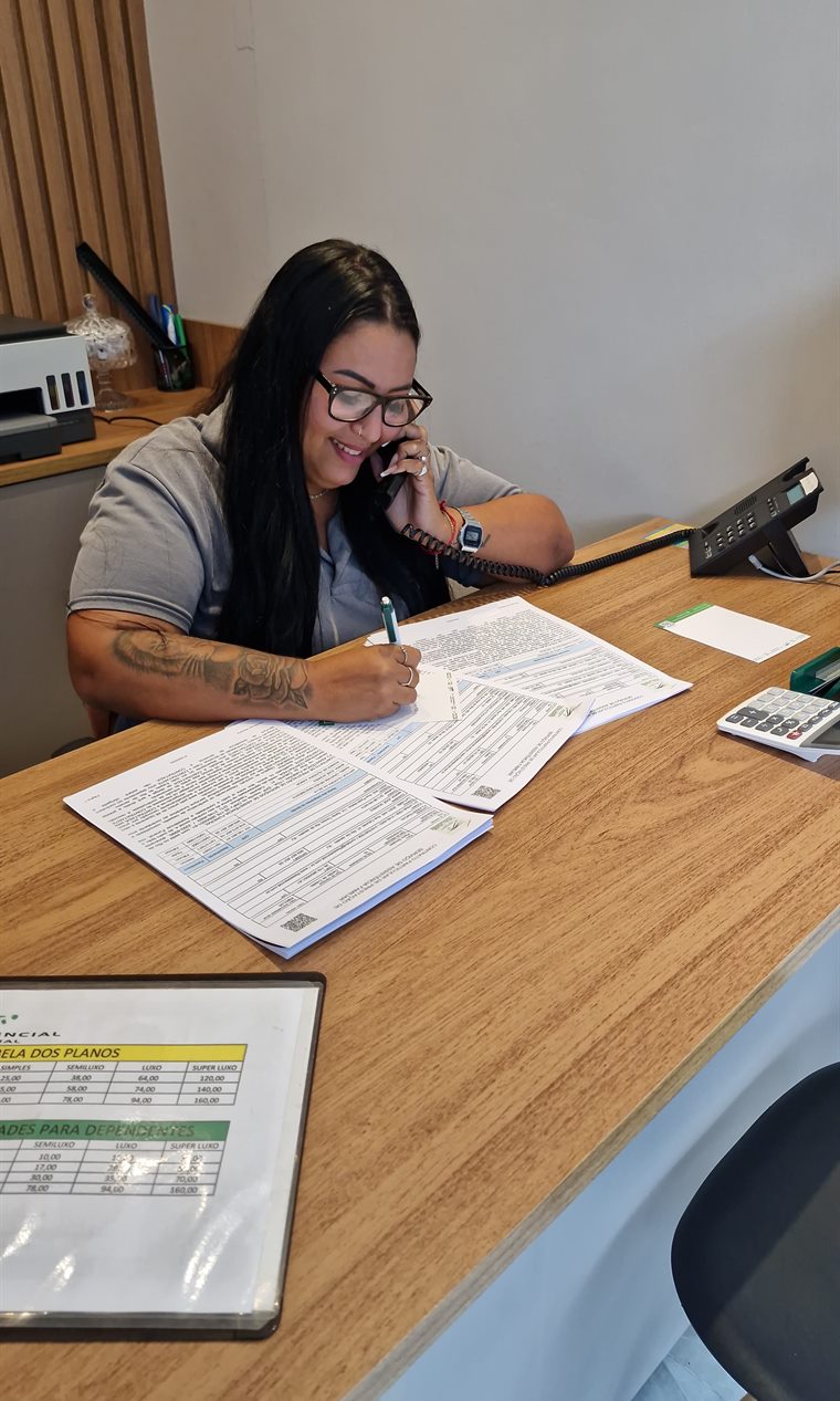 Consultora da F3 Assistencial atendendo por telefone na sede